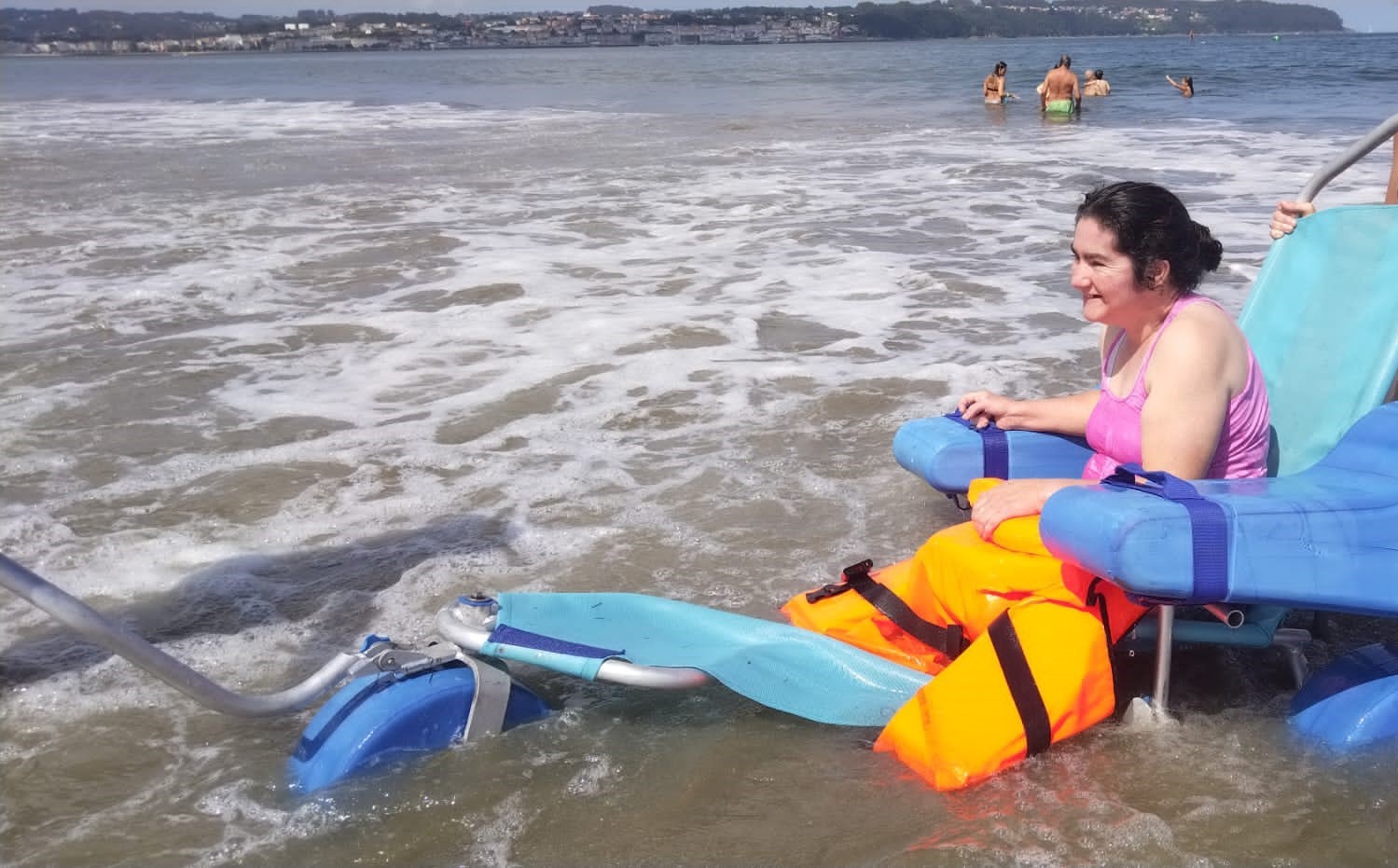 persona en silla de ruedas se baña en la playa
