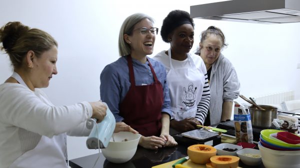 Foto del taller de repostería del segundo ciclo de salud integral de las mujeres donde las participantes se ríen junto con la profesora